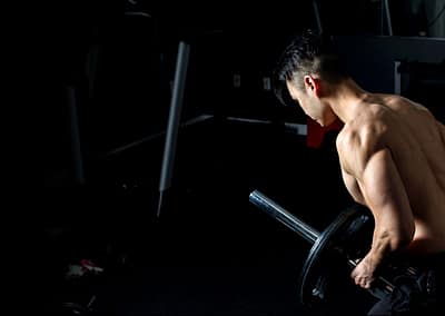 fit asian personal trainer doing bent over rows with landmine